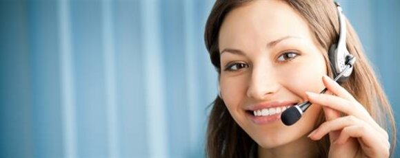 A woman smiling while wearing a headset, indicating she is ready to assist or provide support.